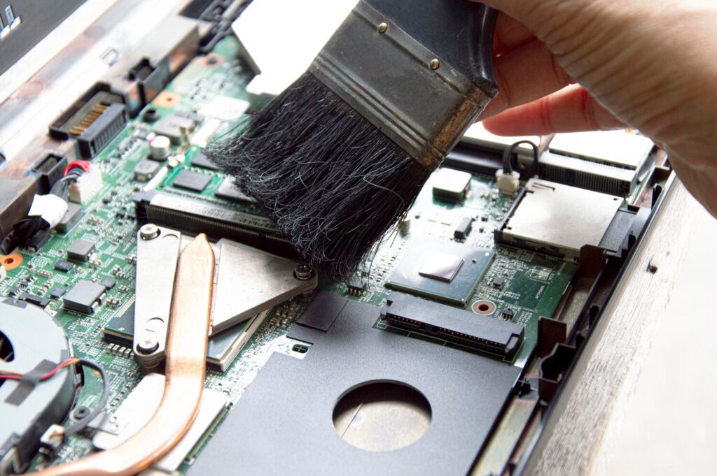 technician using brush clean dusty notebooks 150418 349 technician using brush clean dusty notebooks 150418 349